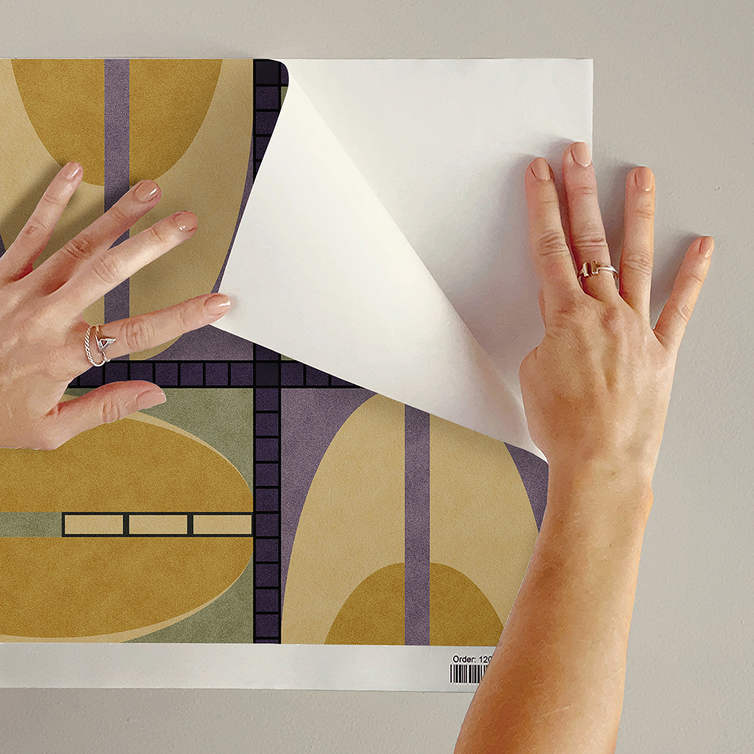 The artwork features a repeating geometric pattern of symmetrical shapes resembling elongated, curved diamonds or petals in various shades of blue and green. Each shape is split vertically with one half filled with a light blue and the other half filled with green or darker blue. The background is a light, almost pastel blue, which provides a soft yet vibrant backdrop. One of the blue shapes near the upper left contains a white starburst element, adding a focal point of brightness to the composition. The overall design conveys a modern, mid-century aesthetic with clean lines and harmonious color contrasts.